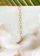Load image into Gallery viewer, Delicate Tia bracelet on marble slab with white flowers at the side and palm leaf at the back