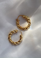 Load image into Gallery viewer, Twirl earrings on white cloth with light play