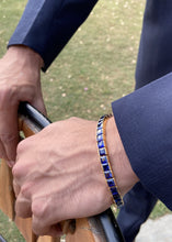 Load image into Gallery viewer, Male model wearing sapphire square cut tennis bracelet with hands placed on a chair