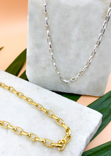 Load image into Gallery viewer, Catena necklace in gold and silver on marble slab with leaves and flowers
