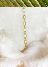 Load image into Gallery viewer, Delicate Tia bracelet on marble slab with white flowers at the side and palm leaf at the back
