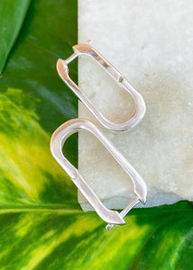 Silver color variant in oblong earrings placed on marble