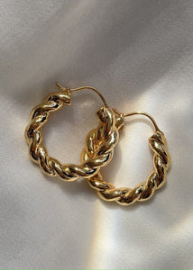 Twirl hoop earrings on a white cloth with rainbow