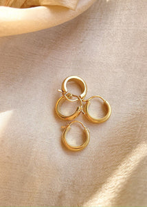 Multiple bold hoops pair on golden cloth in sunlight