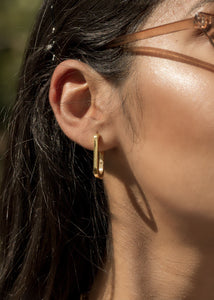 Model wearing oblong earrings with shades on 